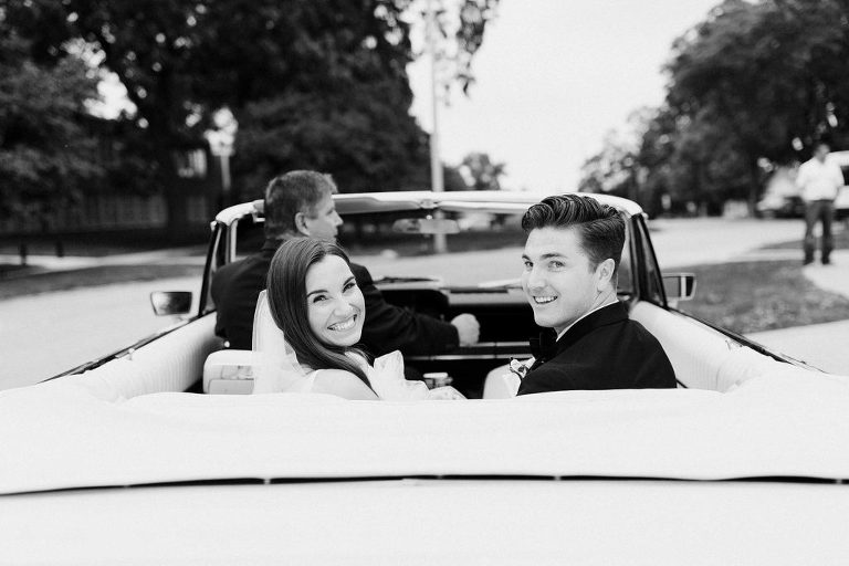Black and white photo of bride and groom in car